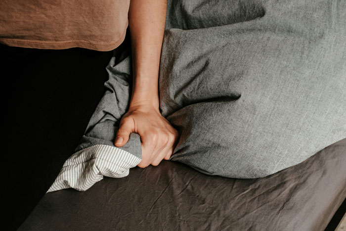 Hand gripping a gray bedsheet, representing the urgency and tension in a predator-related incident involving TikTok. Hand gripping a gray bedsheet, representing the urgency and tension in a predator-related incident involving TikTok.