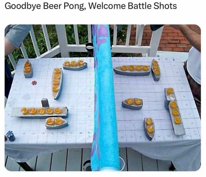Creative battle shots game with shot glasses arranged like battleships on a deck, a funny meme to lighten the mood.