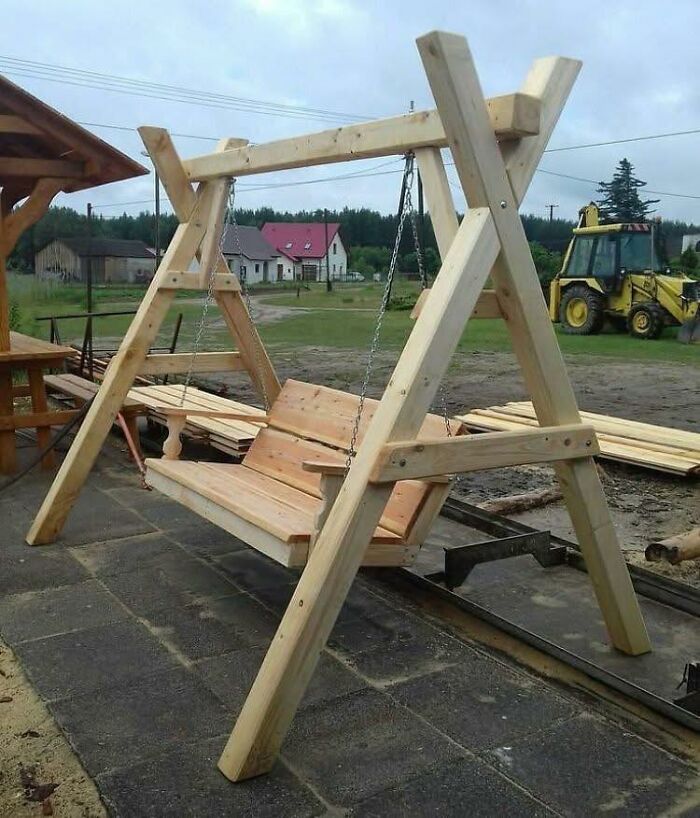 Columpio de madera artesanal al aire libre que demuestra habilidades con la madera en un entorno rural.