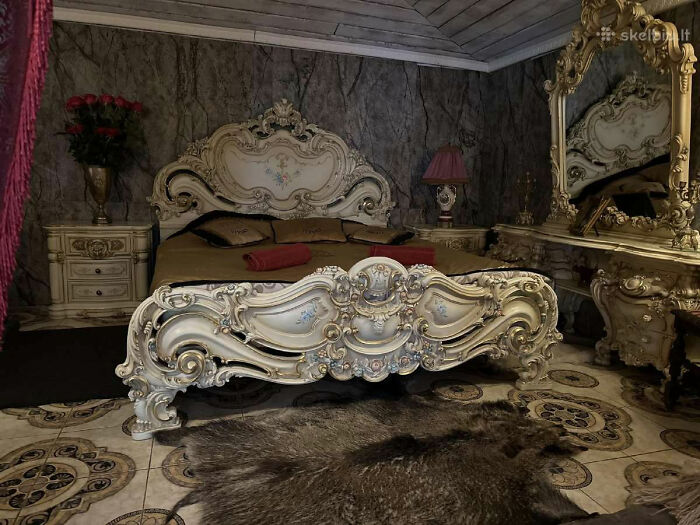 Ornate vintage bedroom with elaborately carved bed and matching furniture in a wild real estate property for sale.