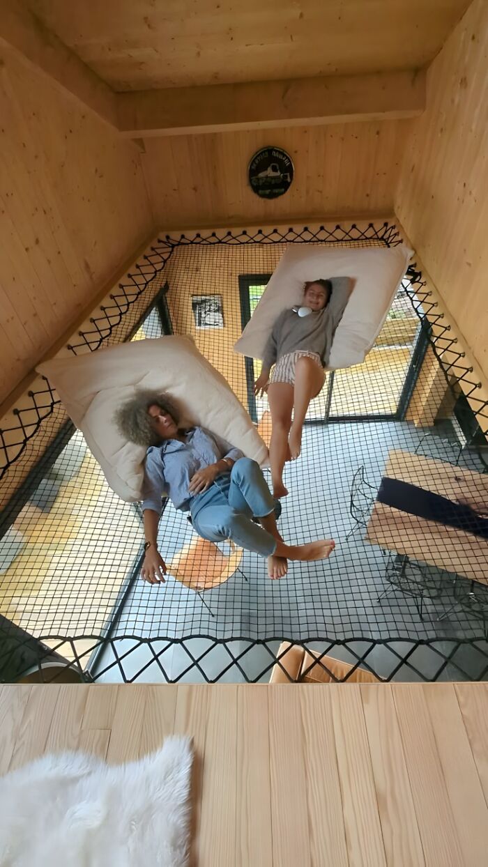 Personas descansando en red suspendida dentro de estructura de madera mostrando proyectos y habilidades con la madera