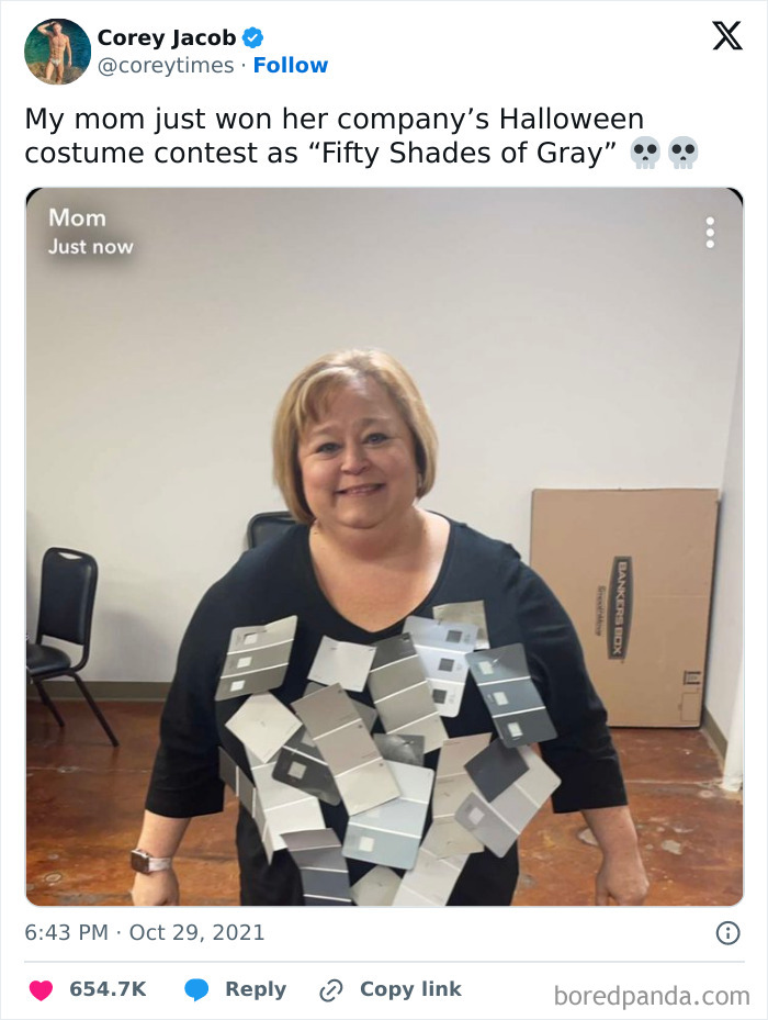 Woman in a creative "Fifty Shades of Gray" Halloween costume made from paint swatches, smiling indoors.