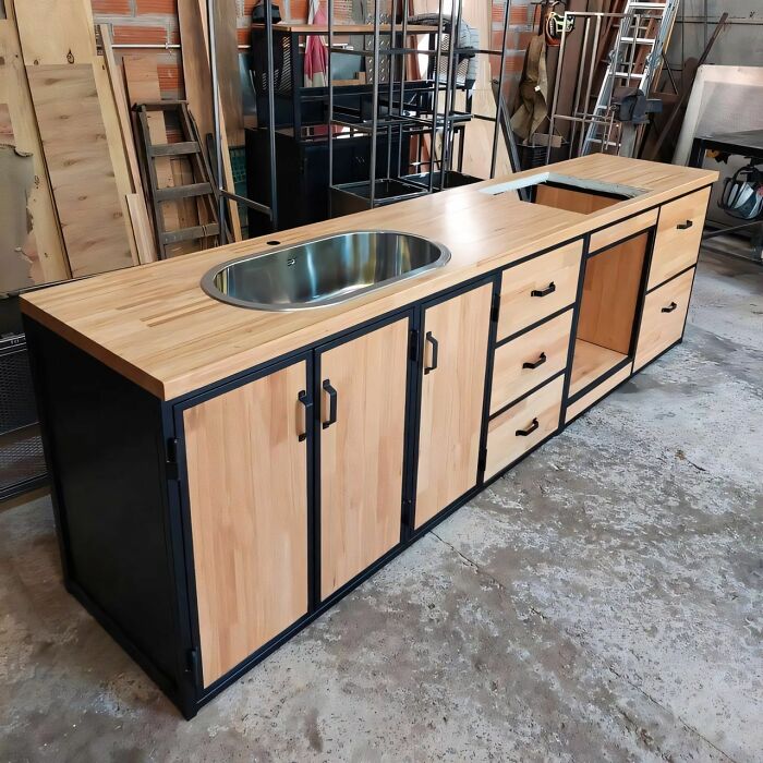 Mueble de cocina de madera con lavabo integrado y cajones, mostrando habilidades en trabajos con la madera.