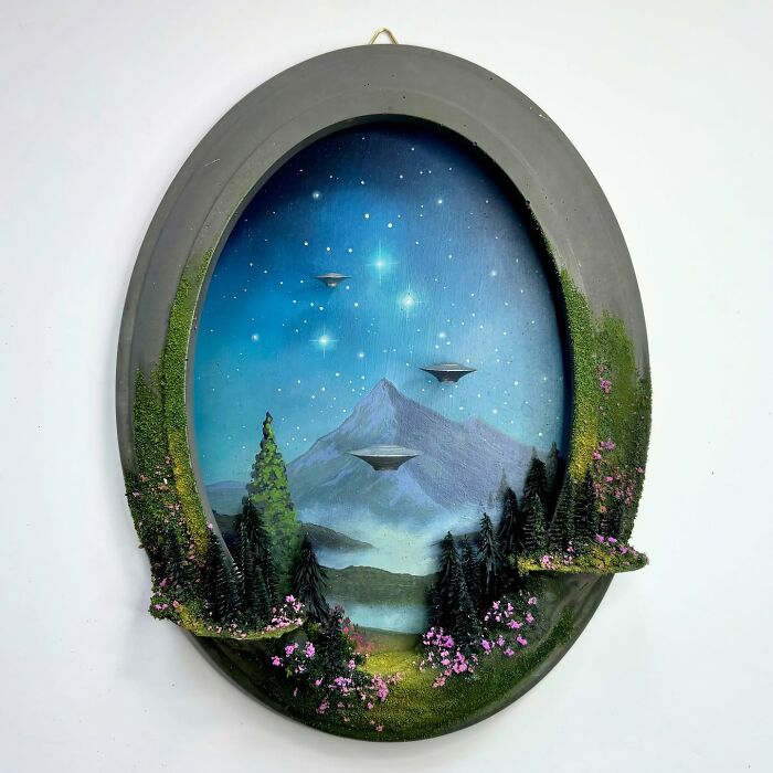 Intricate alien-themed diorama by Caroline Dewison, featuring UFOs over a mountainous landscape under a starlit sky.