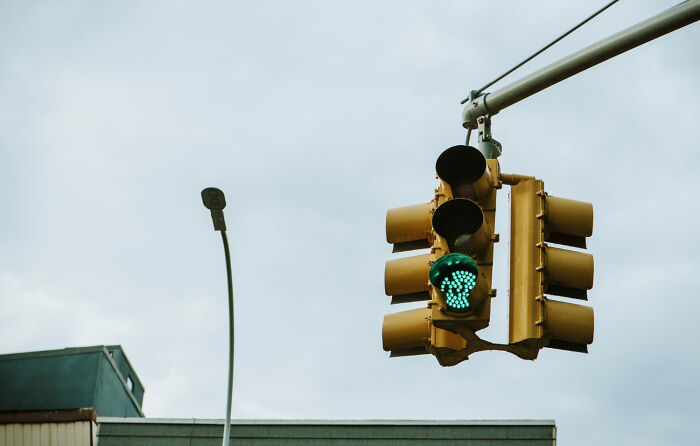 Traffic light showing green, an unexpected lifesaver for pedestrians on a cloudy day.