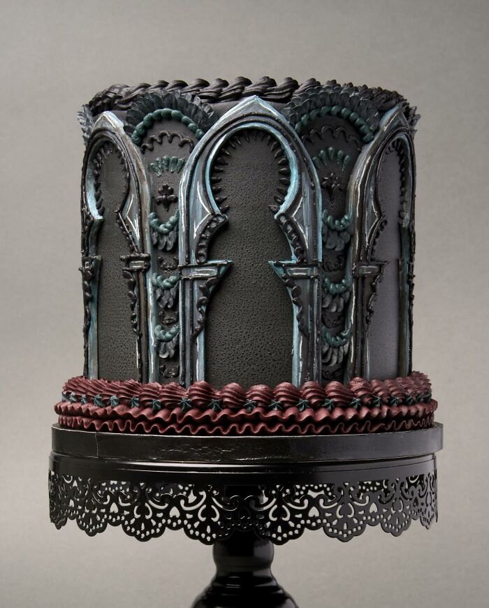 A visually stunning cake with intricate gothic arches on a decorative stand.