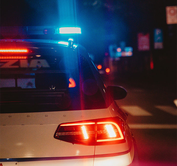 Police car with flashing lights at night, capturing a scene related to stories of people too close to their parents.