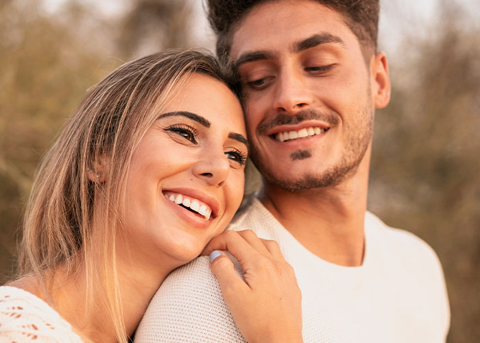 Smiling couple embracing outdoors, representing men sharing marriage cheat code tips that actually work.