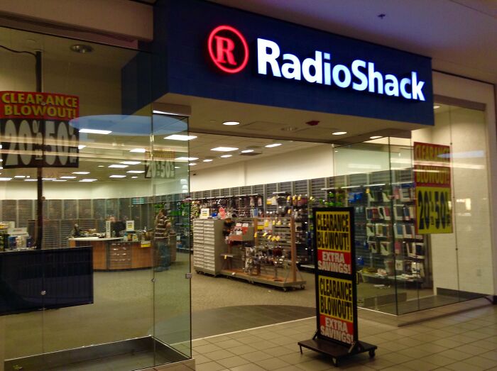 RadioShack store with clearance signs, reflecting retail decline of past decades.