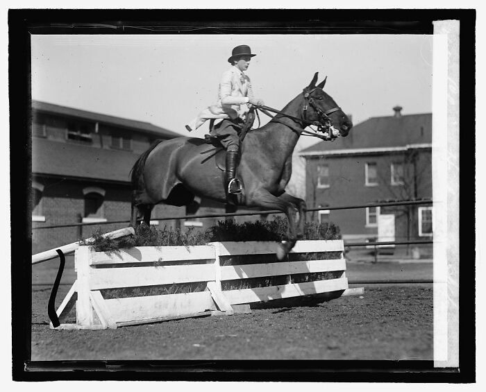 Black and white rare photograph of a rider jumping a horse over a fence, rescued from glass negatives.