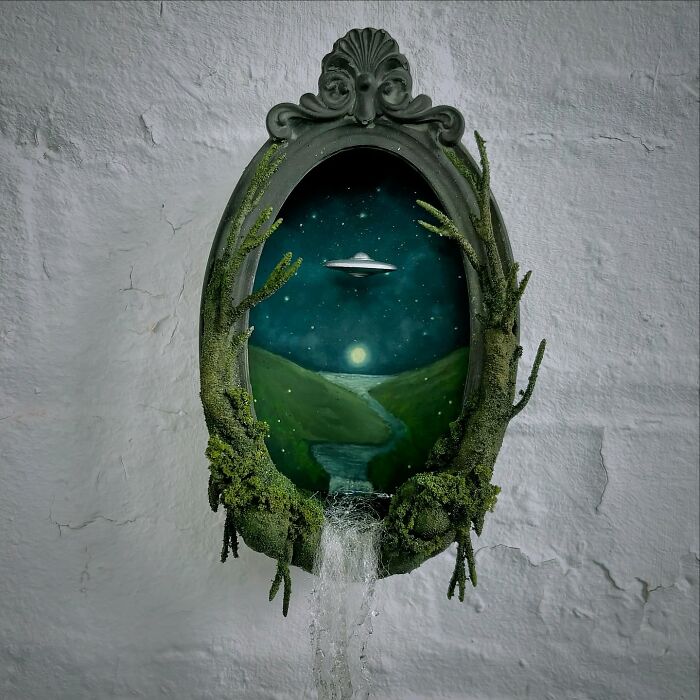 Alien diorama by Caroline Dewison, featuring a UFO in a mystical landscape with a flowing stream.