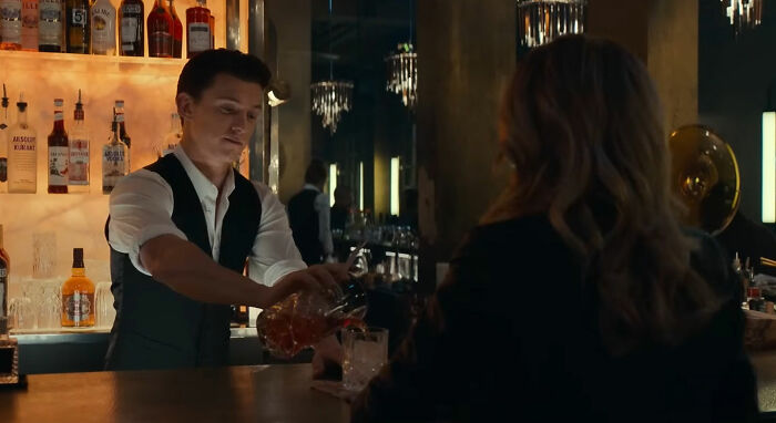 Bartender pouring a drink for a customer at a stylish bar, capturing a scene that looks awesome in movies.