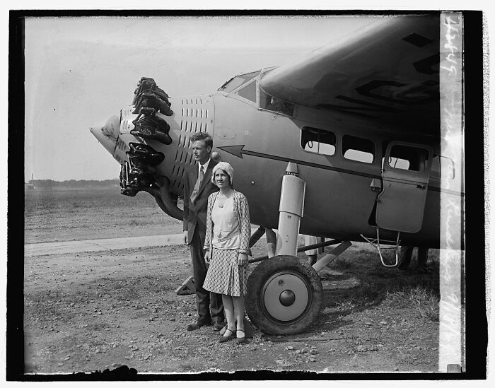 Vintage rare photograph showing a man and woman standing beside an early airplane captured from glass negatives restoration.