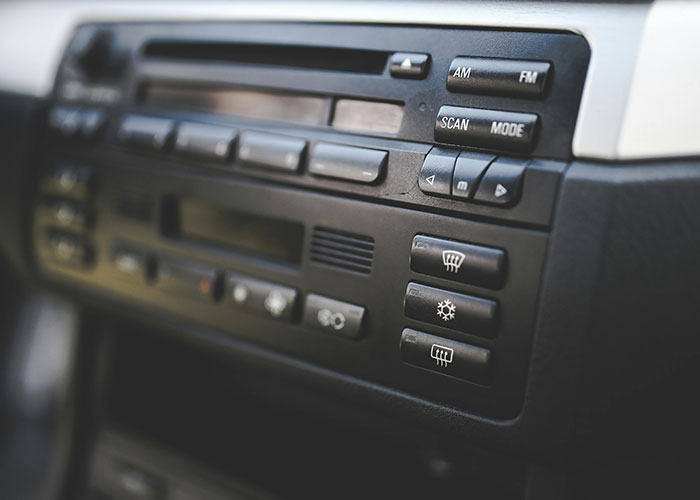 Close-up of a car stereo system with buttons and controls, unrelated to heartbroken people or cheating stories.