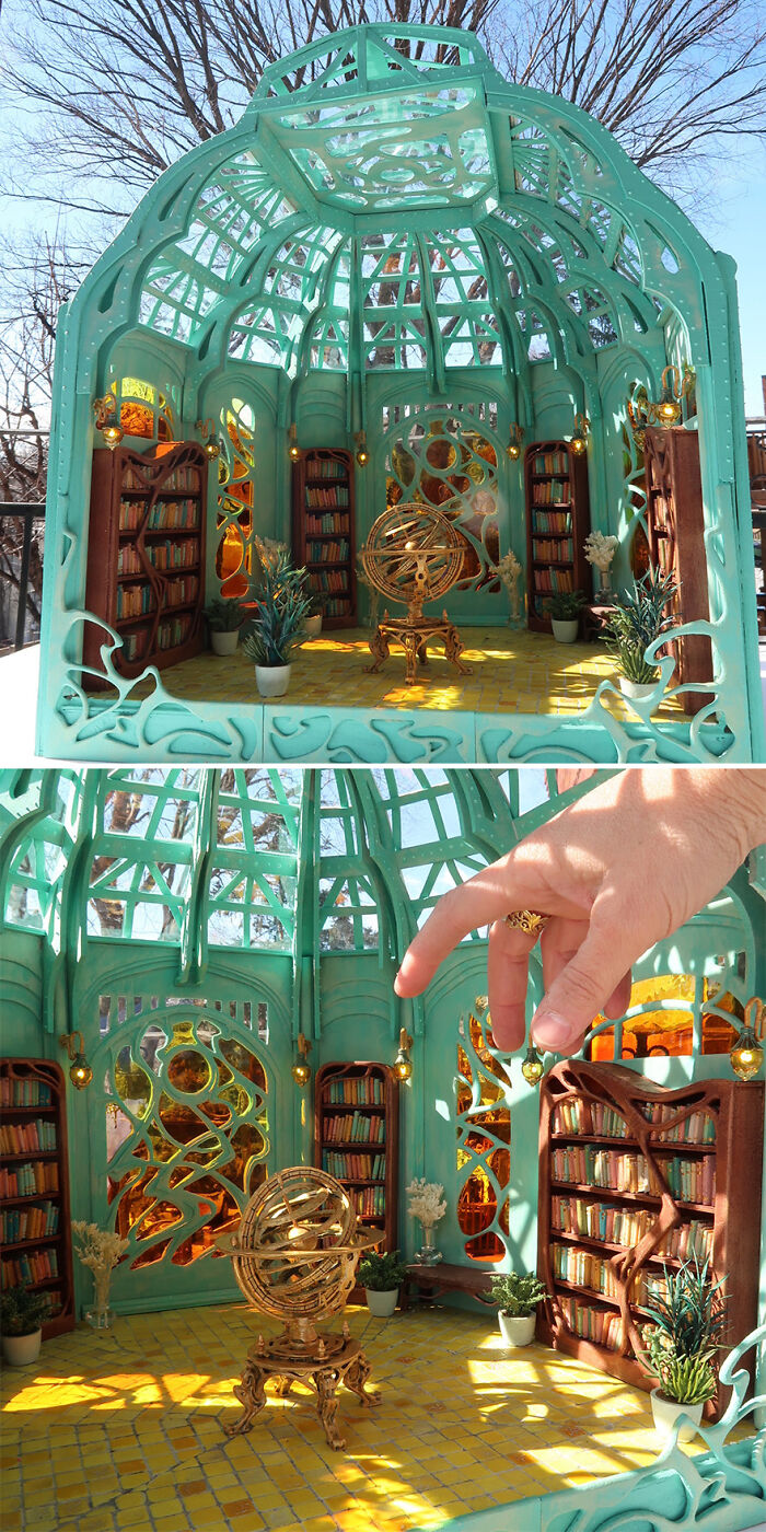 Miniature library scene by Tamar Cohen, featuring intricate teal architecture and bookshelves, with a hand for scale.