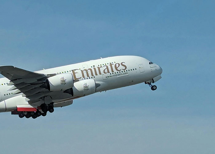 Emirates plane taking off into a clear blue sky.