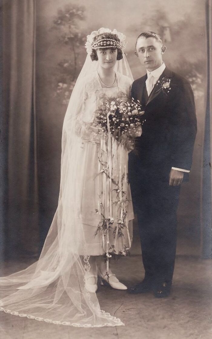 Vintage wedding photo of a bride in a lace veil and groom in a suit, capturing timeless love.