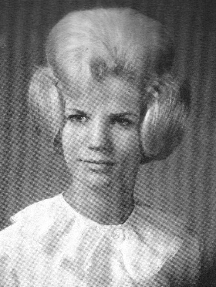Black and white photo of a woman with a voluminous retro hairstyle, capturing vintage hair fashion.