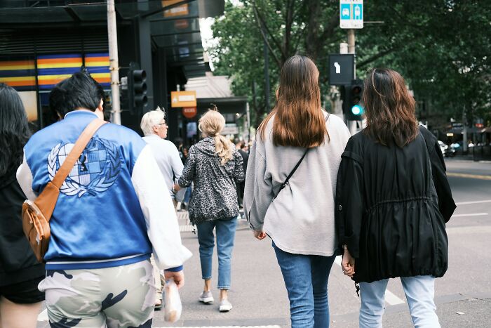 People walking in a European city, showcasing everyday attire and urban life.