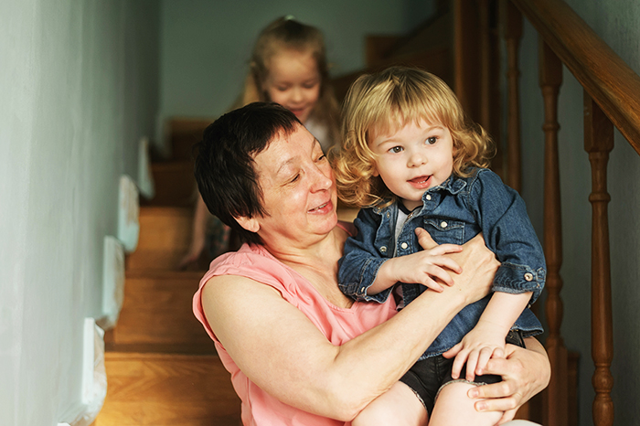 Grandma holding granddaughter on staircase, showing a tender moment related to threatening granddaughter&rsquo;s life for nuts.