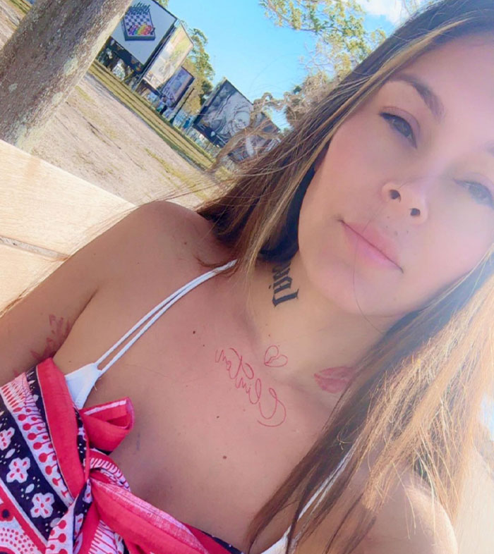 Pregnant mom in colorful top on park bench, sunny day, nature in the background.