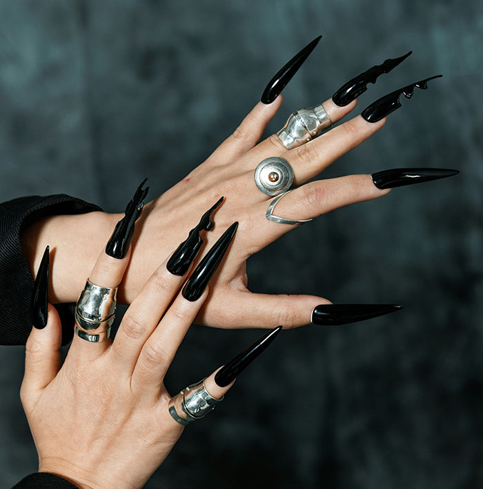 Hands with long, sharp black nails and silver rings; central to a patriarchy debate. Hands with long, sharp black nails and silver rings; central to a patriarchy debate.