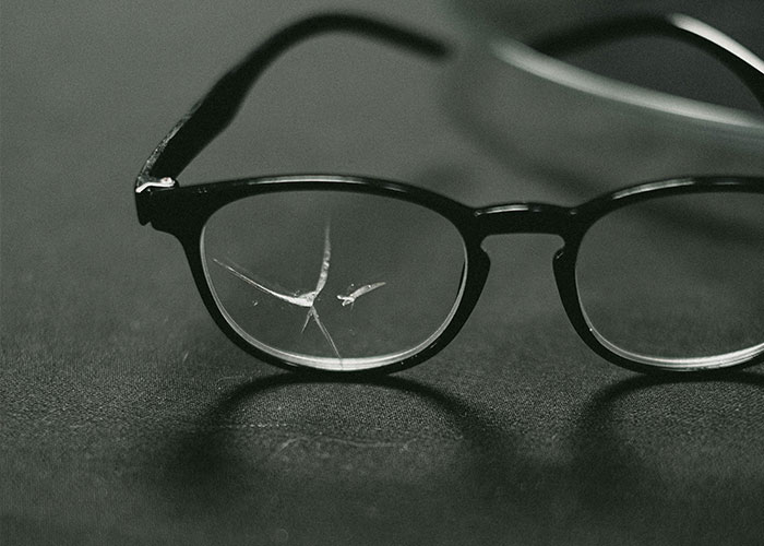Broken glasses resting on a dark surface, symbolizing the struggles with ineffective teachers.