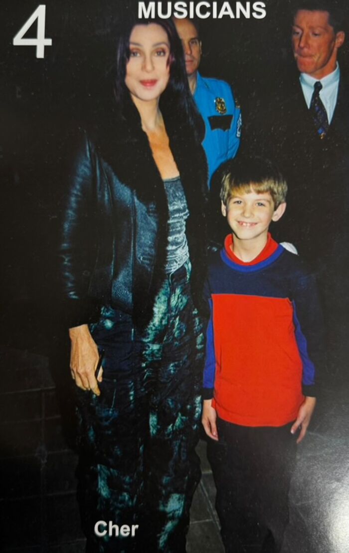 Young boy posing with a celebrity musician in a casual setting, showcasing early life photos with famous people.