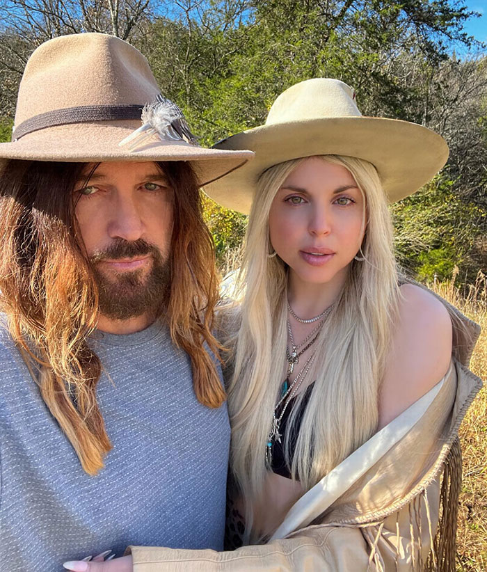 A couple wearing hats poses outdoors, stirring reactions with debut romance.