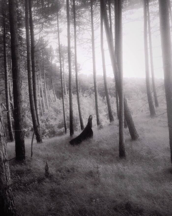 Dreamy dark escapism photography featuring a mysterious figure in a misty, forested landscape.