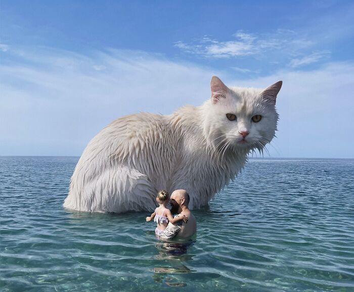 Man and child in ocean with a giant, surreal cat in the background, creating a whimsical scene.