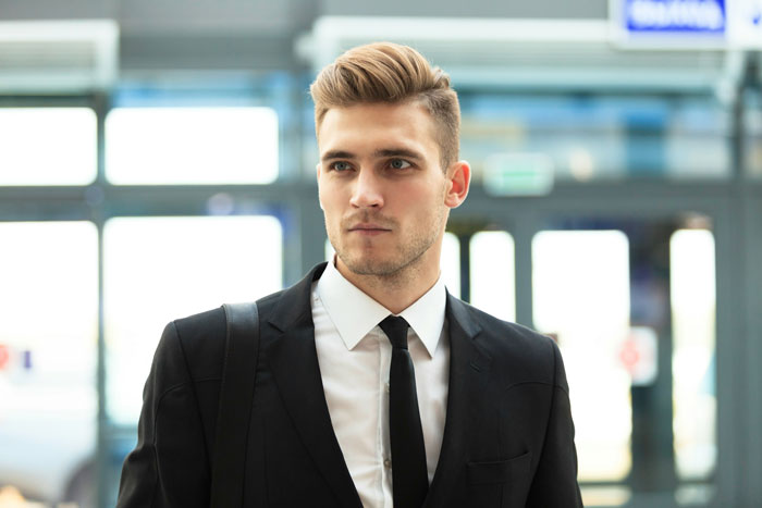 Professional man in a suit, standing confidently at a job hunting event.