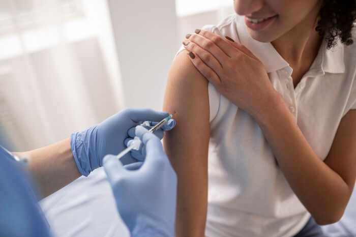 Person receiving a vaccination in the arm, highlighting unnoticed scientific advancements.