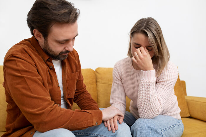 Man comforting a worried woman on a couch, sharing their thoughts on the scariest things.