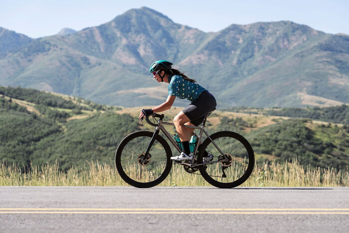Cyclist riding on a mountain road, highlighting seemingly harmless everyday activity surrounded by scenic views.