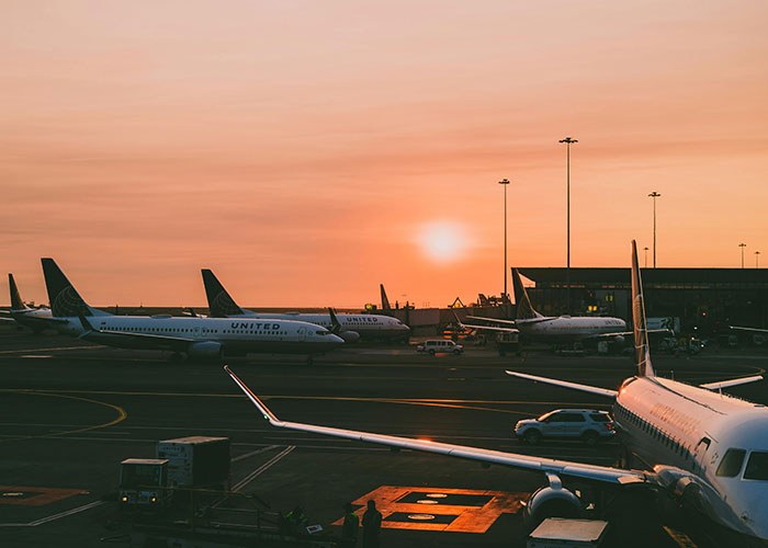 Plane during sunset at airport terminal, evoking "you've gotta be kidding me" travel stories.