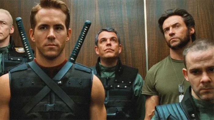 Wholesome stars in action scene; four men in tactical gear stand in an elevator, looking serious.