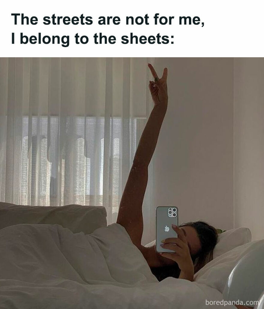 Woman in bed with a phone, arm raised in peace sign, capturing a relatable Girl Posts meme moment.