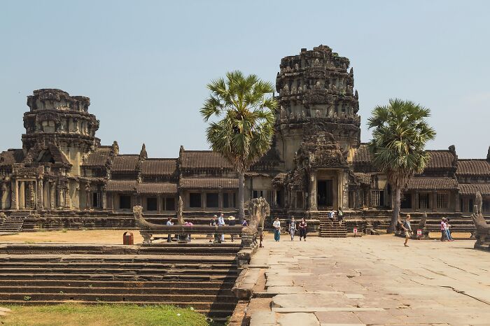 An ancient temple showcasing remarkable, lesser-known architectural wonders with stone carvings and palm trees.