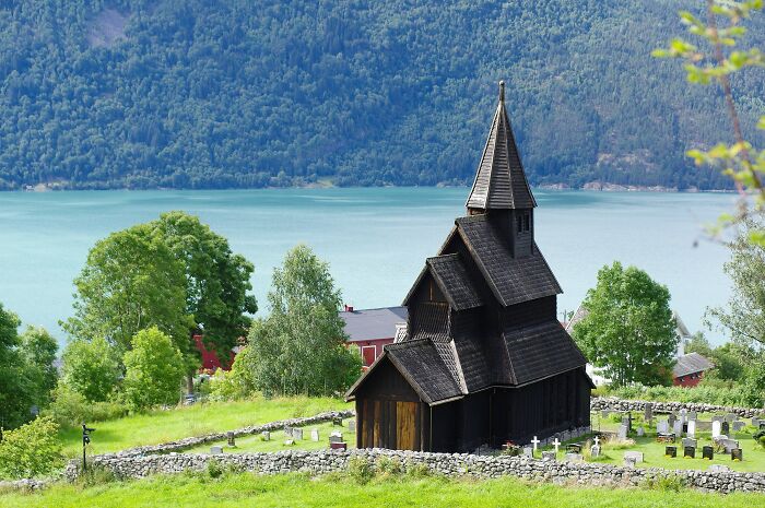 A wooden church nestled by a lake, showcasing architectural wonders in a serene landscape.