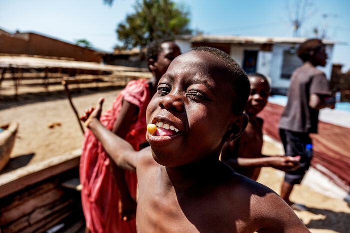 Boy smiling with candy, outdoors, shortlisted for 2025 World Food Photography Awards.