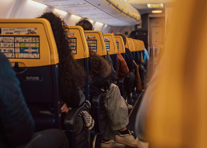 Passengers seated on a plane, yellow headrests visible, creating a cozy atmosphere during a flight journey.