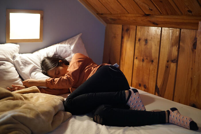 A person sleeping on a bed in a cozy room, highlighting everyday things that might be surprisingly dangerous.