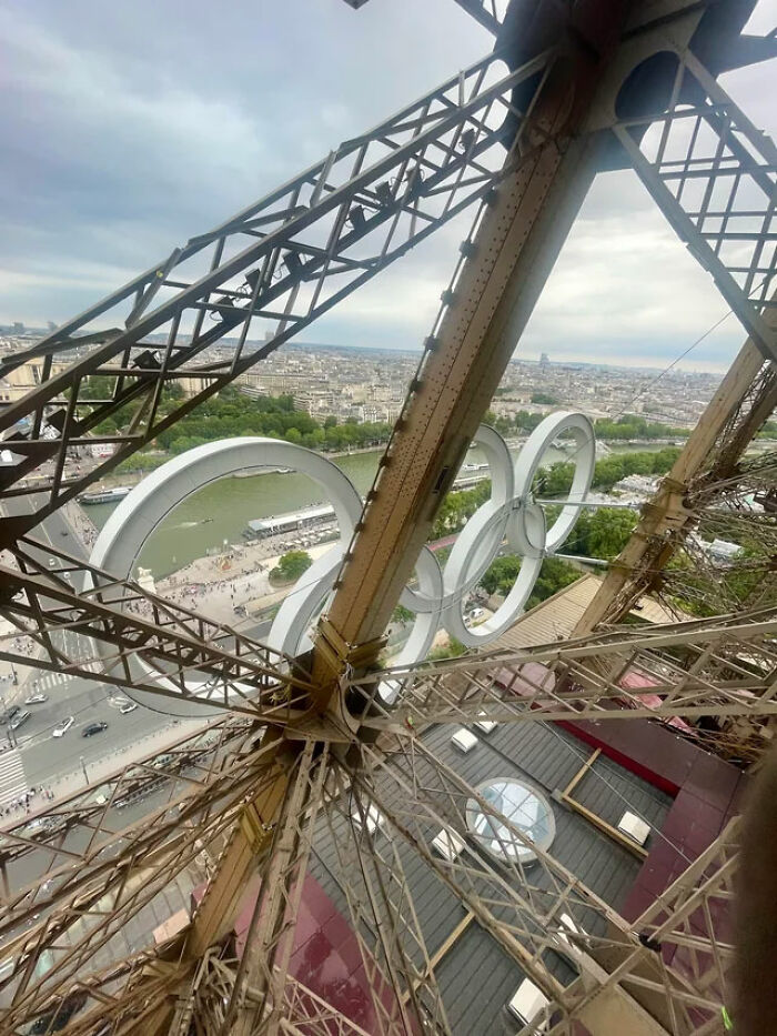 View from Eiffel Tower showing Olympic rings and Paris cityscape, providing a new perspective on this famous place.
