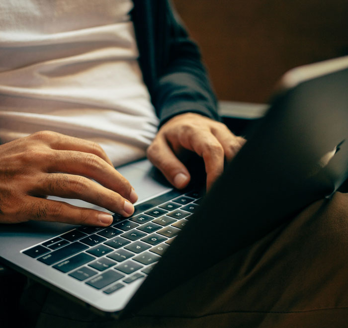 Person typing on a laptop, symbolizing internet hacks for making life online easier.