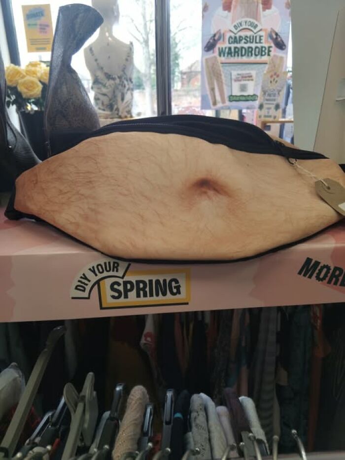 Bizarre secondhand shop find, a bag resembling a hairy belly, displayed on a spring-themed store shelf.