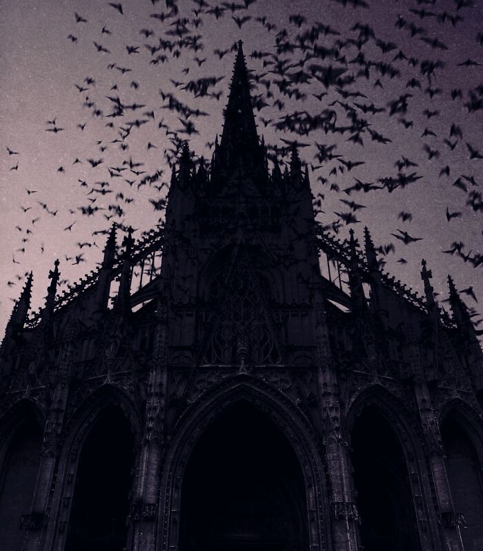 Dark escapism photography featuring a gothic cathedral silhouette against a sky filled with bats by Nona Limmen.