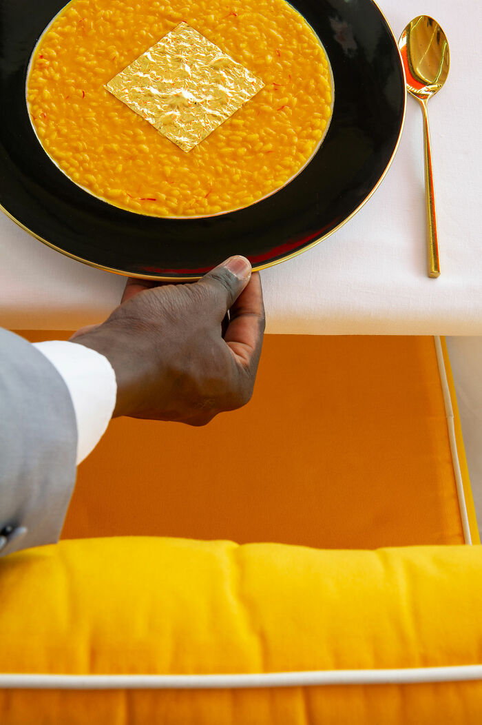 Golden risotto on black plate with gold leaf, from World Food Photography Awards 2025 shortlist.