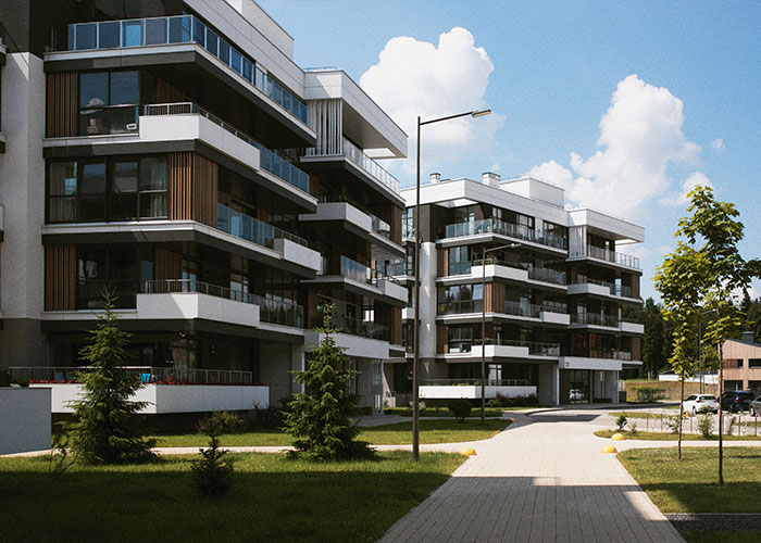 Modern apartment buildings with balconies under a blue sky, highlighting HOA community living.