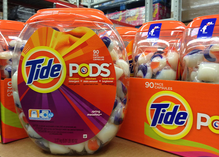 Tide Pods containers on a store shelf, showcasing the popular detergent product.